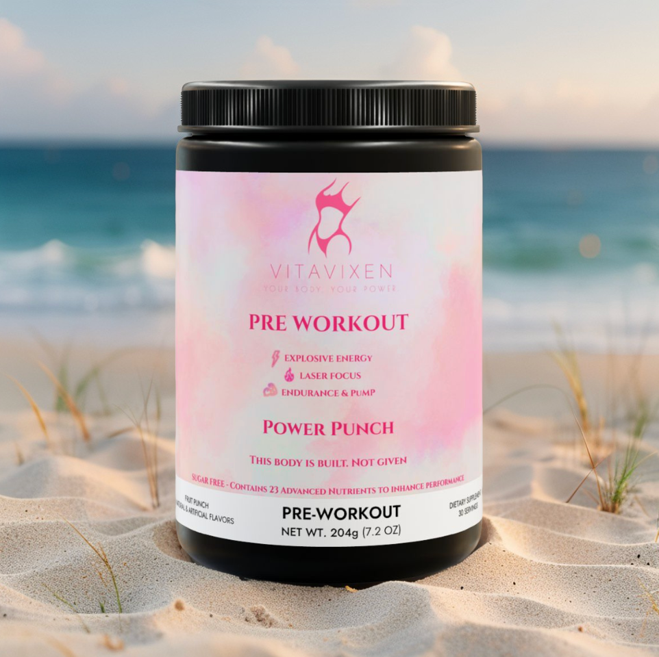 VitaVixen Fruit Punch Pre-Workout supplement for women in a pink tub, resting in sand with blurred ocean background